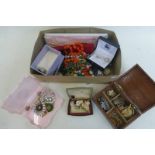 A box of assorted costume jewellery including coronation and a liberation brooch.