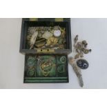 A jewellery box with an assortment of silver jewellery including a charm bracelet.