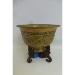 A large Chinese brass bowl decorated with a cloud dragon with a seal mark to the base, raised on a