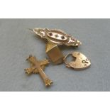 An assortment of 9ct gold jewellery including a brooch, a crucifix, a padlock etc. approximately 8.