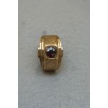 A gentleman's 9ct gold signet ring set with a garnet stone, approximately 7.2g.