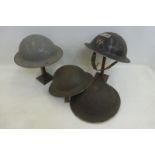 A warden's tin hat and three others.