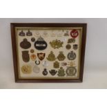 A framed display of 33 military and G.P.O. badges. The G.P.O. 20 badge is approximately 2 3/4 x 2