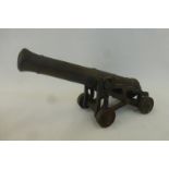 A brass signal cannon with a barrel length of approximately 10 1/4", on a metal carriage and