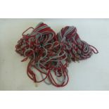 A large quantity of red and grey cord lanyards.