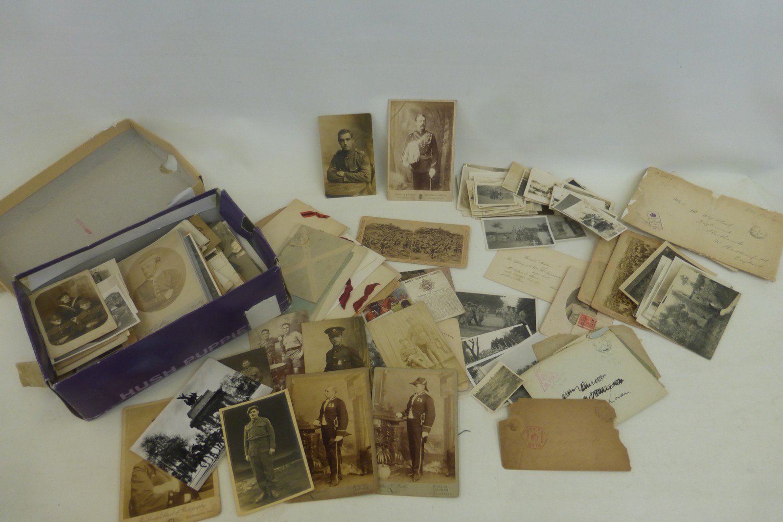 A shoe box full of original military photographs, postcards and ephemera.