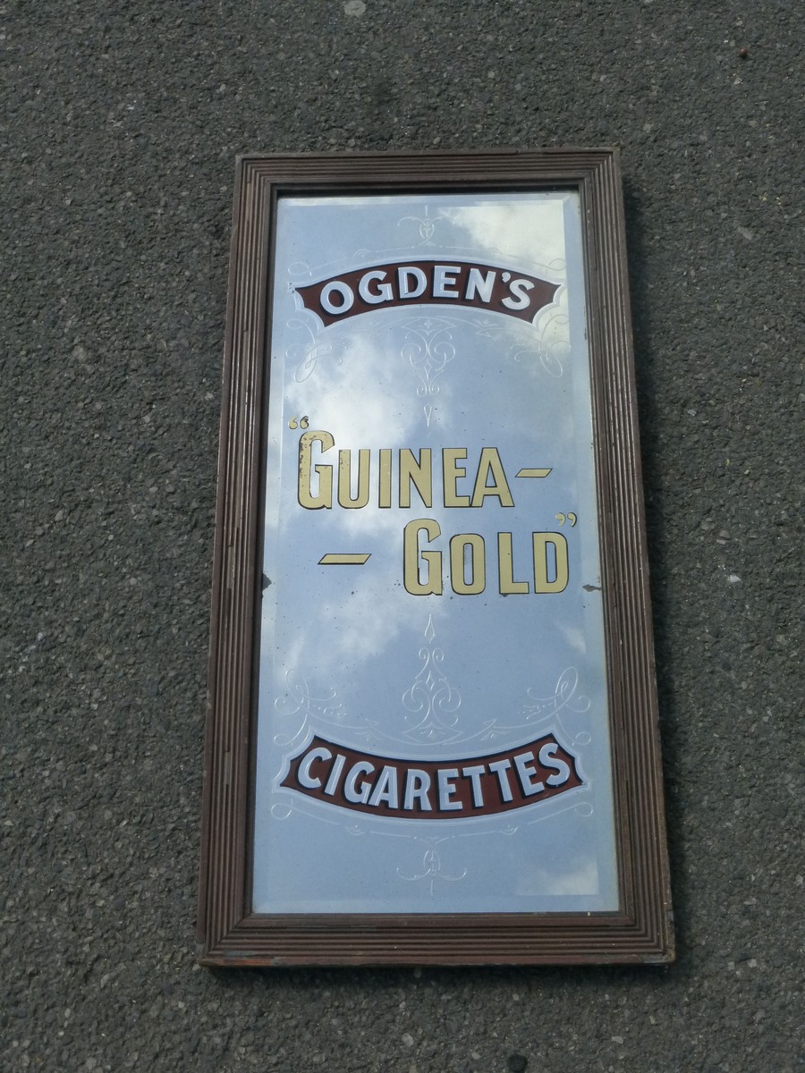 An Ogden's Guinea Gold Cigarettes advertising mirror, 13 1/2 x 27 1/2".