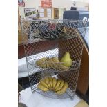 A wirework corner three tier basket and two others with a selection of fake fruit for museum display