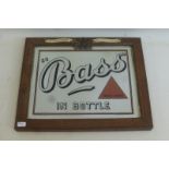 A 'Bass in Bottle' advertising mirror set within an original stamped oak frame with celluloid