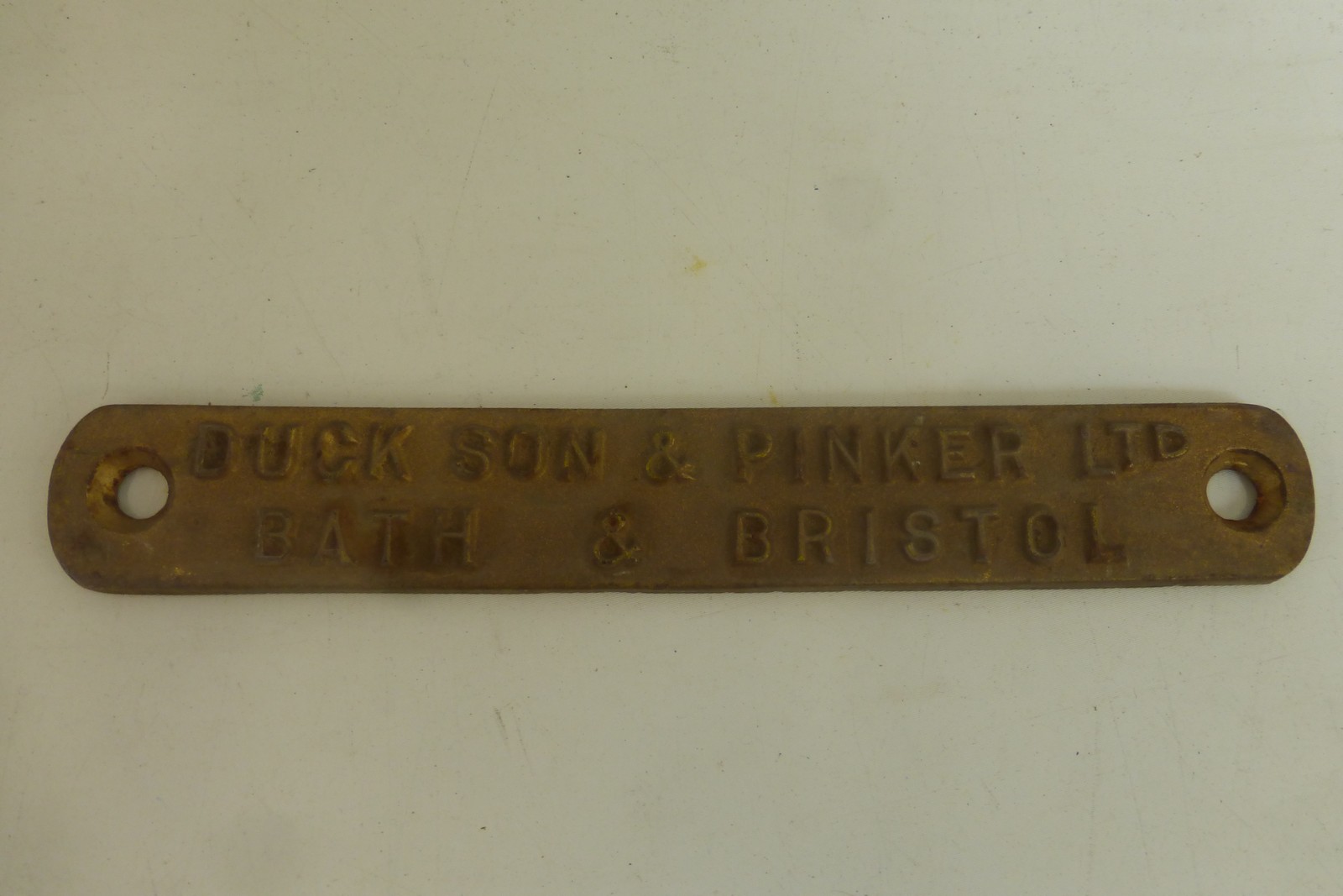 A rectangular cast iron plaque for Duck Son & Pinker Ltd, Bath and Bristol, 10 1/4 x 1 1/2".