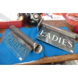 Two glass illuminated signs for "Gentlemen" and "Ladies".