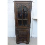 An oak part glazed floor standing corner cupboard.