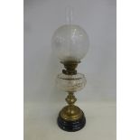 A Victorian brass oil lamp with a cut glass reservoir and an etched bulbous shade.