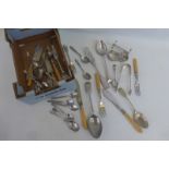 An assortment of flatware including a pair of silver sugar nips and a napkin ring.