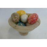 An alabaster miniature urn containing assorted stone eggs.