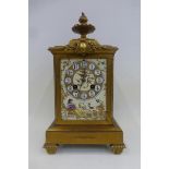 A 19th Century French gilded eight day mantel clock with striking movement and a flame finial,