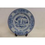 An 18th Century Chinese blue and white charger, the central scene depicting three figures set within