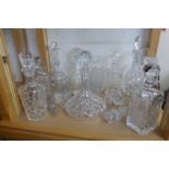 A selection of cut glass decanters and some spare stoppers.