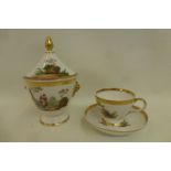 A Continental cup and saucer with matching lidded sucrier decorated with a gilt band, foliage,