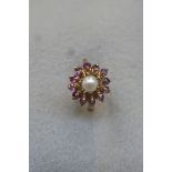 A 9ct gold dress ring set with a central pearl surrounded by amethysts, size R.