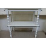 A white painted rectangular kitchen table unusually with a brass bar to each end for hanging