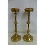 A pair of brass ecclesiastical style candlesticks, 19" tall.