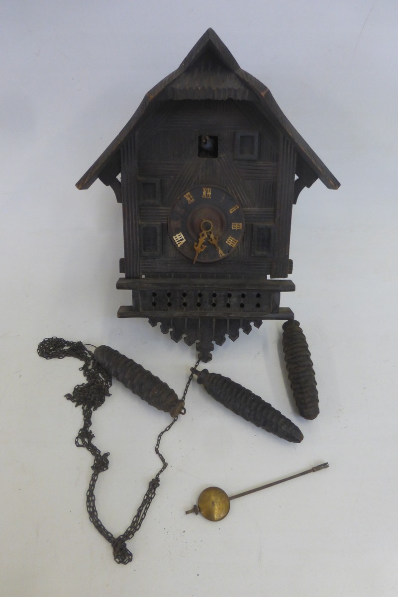 A wooden cuckoo clock with weights.