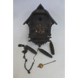 A wooden cuckoo clock with weights.