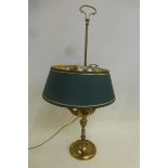 A brass table lamp with four branches with a green shade.