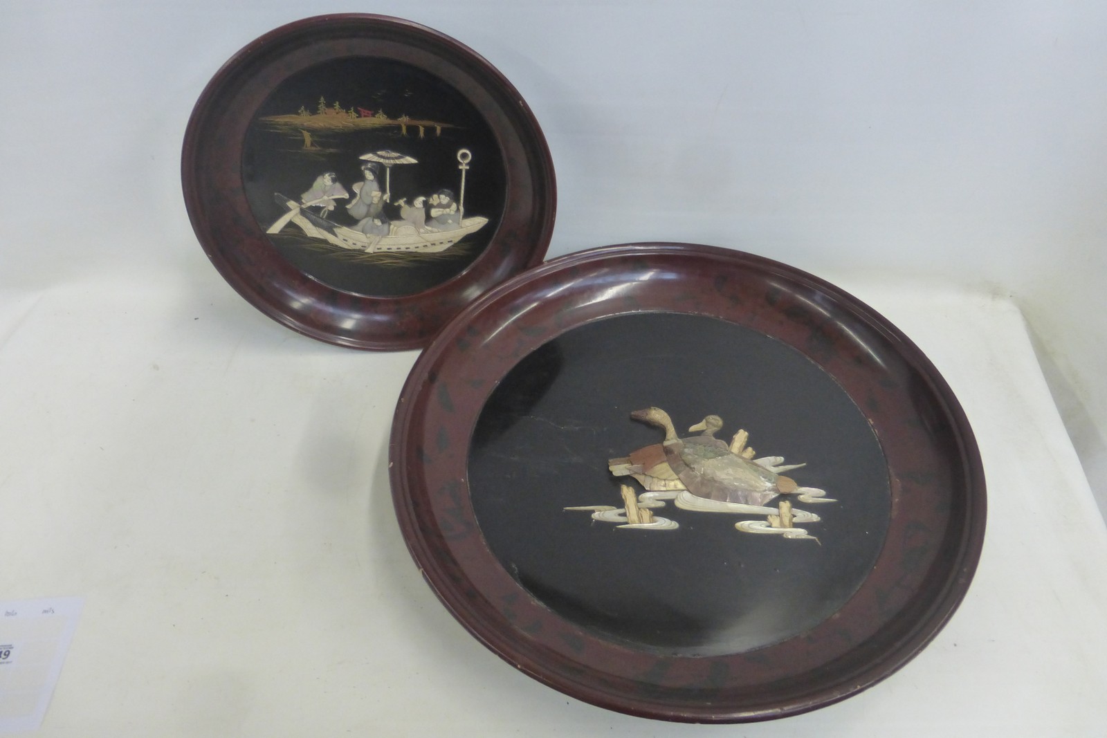 A Japanese chinoisserie lacquered shibayama circular wall plaque, the scene of figures in a boat