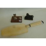 A silver 'jockeys outfit' pen holder marked .925, an ivory cake slice/card turner and a brass lion