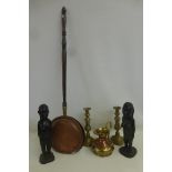 A pair of similarly carved native African semi-clad females, a pair of brass candlesticks, a warming