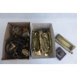 Two boxes of brass door furniture including letterboxes, various brass curtain rings, light switches