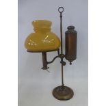 An unusual brass table lamp with adjustable height and mustard coloured glass shade.