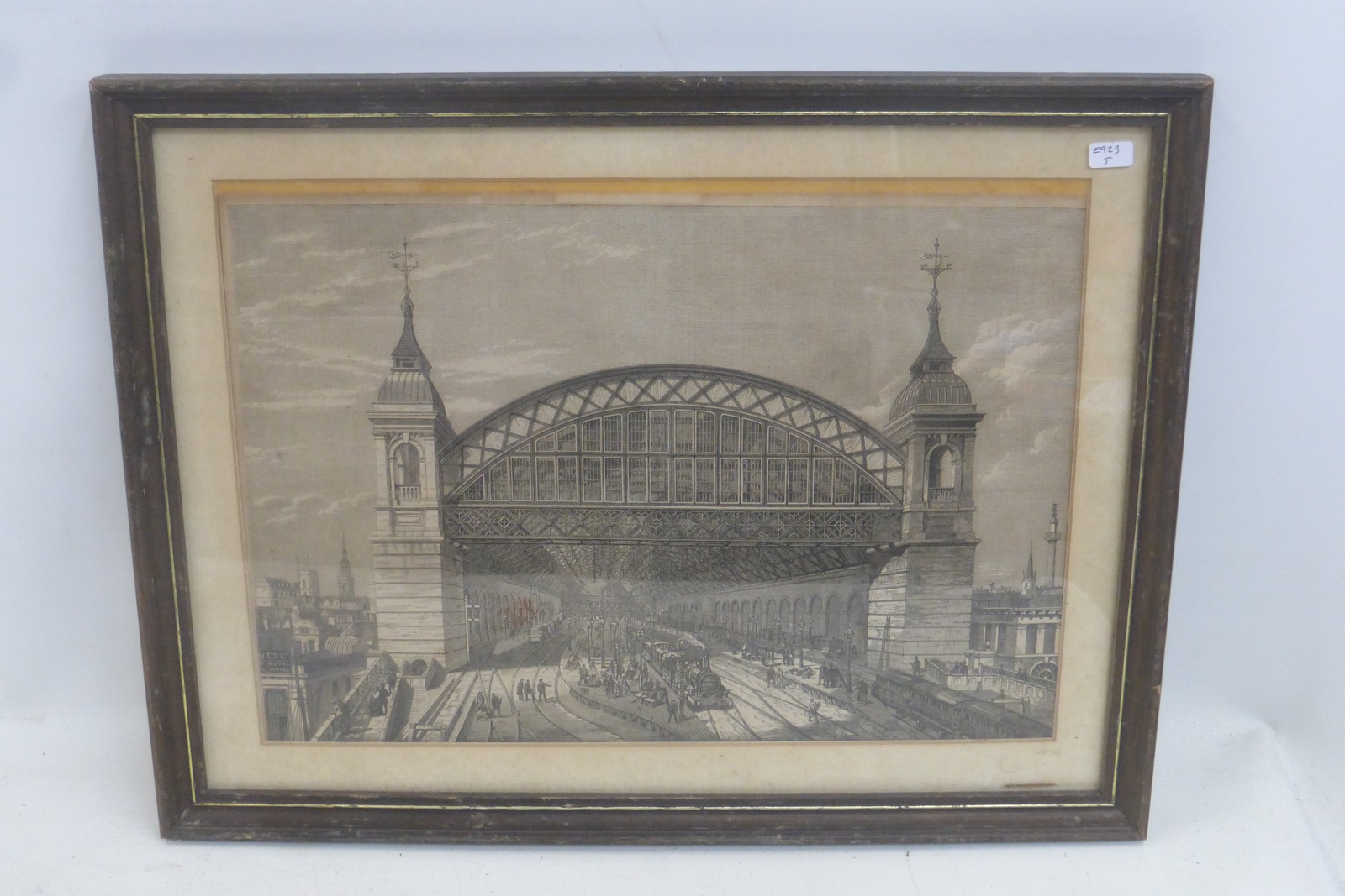 A framed and glazed black and white railway print depicting a Victorian train station, titled