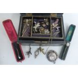 A jewellery box containing an assortment of items including various lapel pins, one 9ct gold,