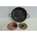 A Victorian copper two handled jam pan, a circular copper saucepan lid and an ornate brass salver,