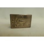 A Continental silver matchbox holder with embossed decoration depicting a figure by a tree with farm