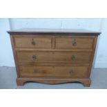 An Edwardian inlaid oak chest of two short over two long drawers, raised upon bracket feet.