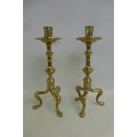 A pair of Classical brass candlesticks of large scale with drip pans and tripod paw feet.