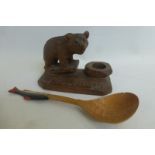 A Black Forest carved wooden candle holder in the form of a strolling bear, together with a Folk Art