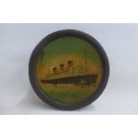 A circular biscuit tin depicting The Queen Mary to the lid.