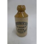 A miniature stoneware ginger beer bottle advertising Tuddenham Bros. Tunbridge Wells, 2 1/4" high.