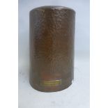An oversized hand beaten copper thimble for a shop display window bearing a brass plaque with the