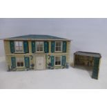 A tinplate dolls house and garage beside.