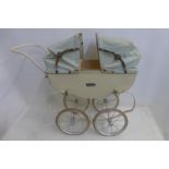 A Tri-ang dolls pram unusually with a double folding hood.