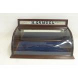 A mahogany counter top display case with curved glass front and glass upstand advertising H.