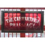 A rectangular ruby glass sign advertising The Camarthen Pharmacy, 38 x 20".