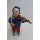 A Schuco clockwork part tinplate figure a clown playing the violin.