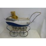 A Tri-ang tinplate dolls pram and a 1950s teddy bear.